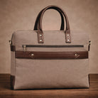 Brown leather and canvas handbag on a wooden surface with a brown background