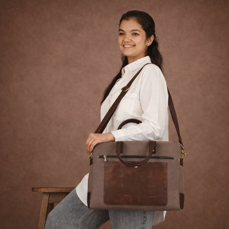 Woman holding a brown canvas leather bag against a brown background
