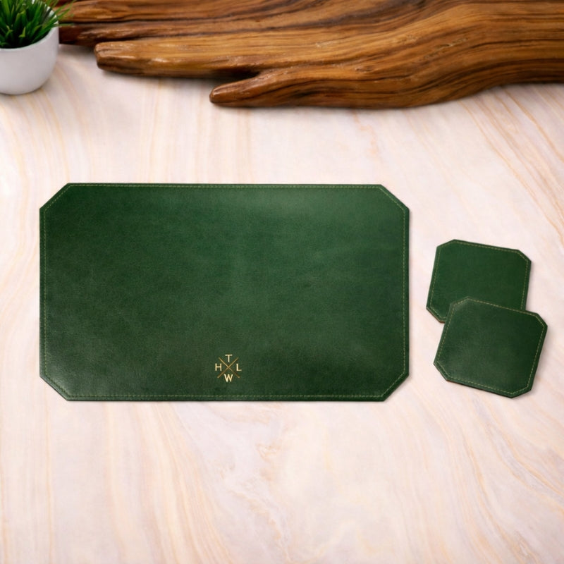 Green leather placemat and coasters with a logo on a wooden surface