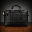 Black leather briefcase on a wooden surface with a dark background