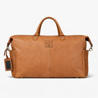 Brown leather duffel bag with a visible brand tag on a white background
