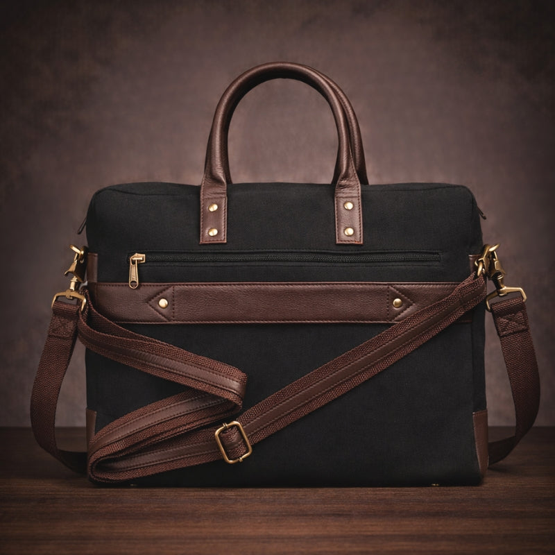Black canvas & leather bag with brown straps on a wooden surface and dark background
