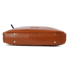 Tan leather bag with gold studs on a white background