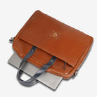 Tan leather bag with a gray strap on a white background