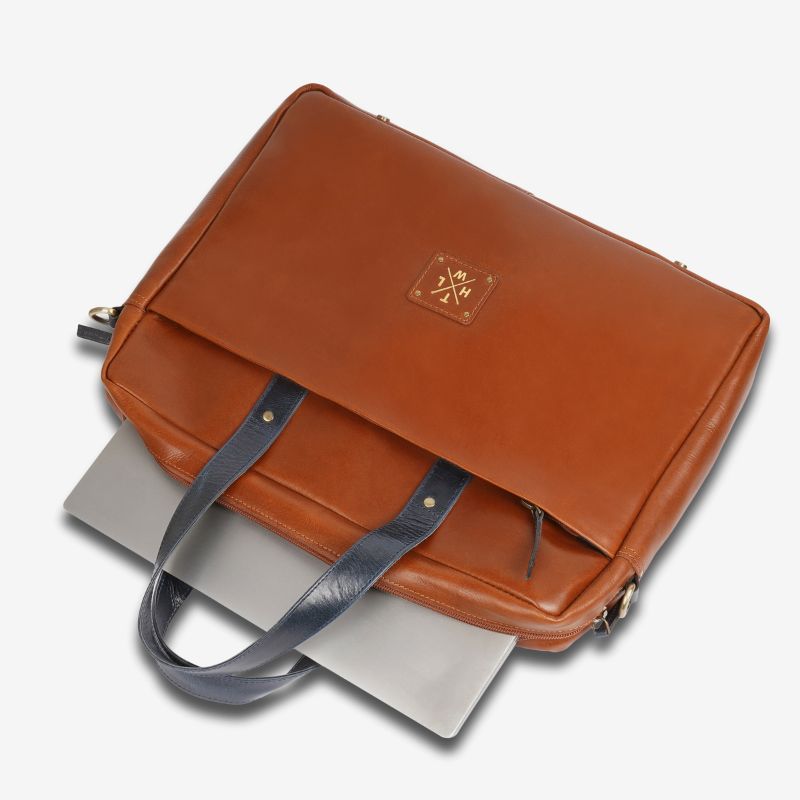 Tan leather bag with a gray strap on a white background