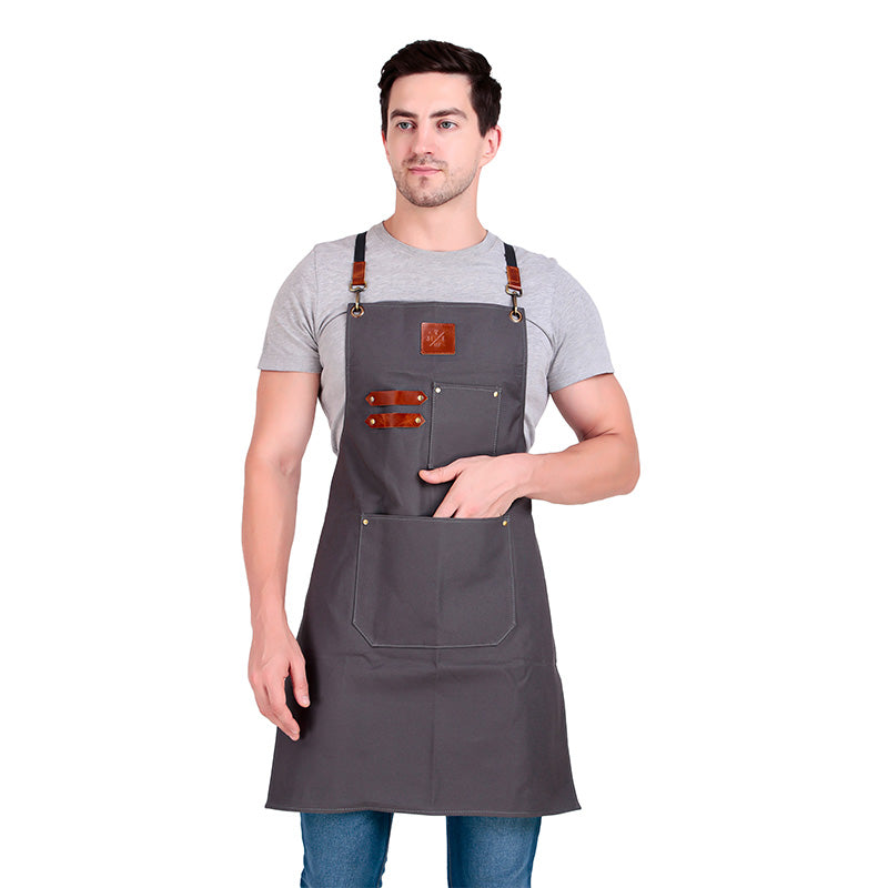 Man wearing a gray apron with leather straps on a white background