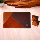 Brown leather placemat with two coaste with geometric design and coasters on a wooden surfac