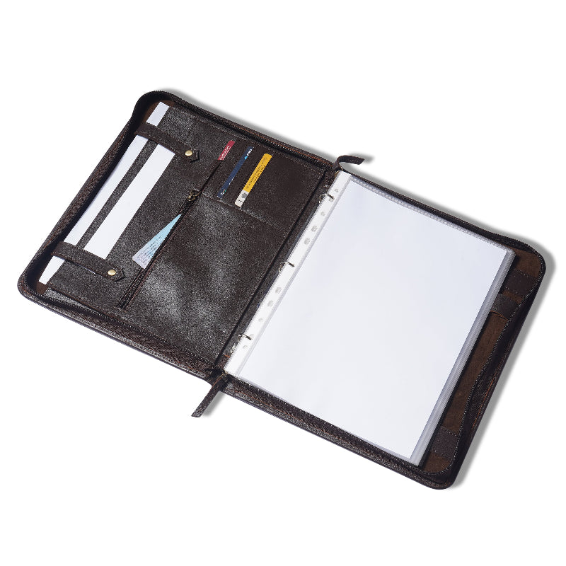 Open leather-bound planner with pen holder and blank pages on a white background