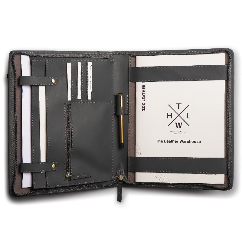 Open black leather office folder with multiple compartments, card slots, pen holder, zipper pocket, and a notepad labeled “The Leather Warehouse.”