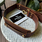 Brown leather bag with a phone inside on a woven surface