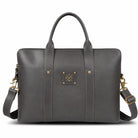 Gray leather laptop bag with gold accents on a white background